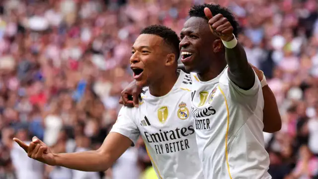 Kylian Mbappe and Vinicius Jr celebrating a goal together for Real Madrid.