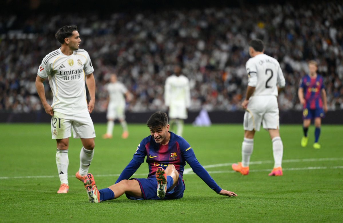Pedri clutching his leg in pain during Barcelona’s match against Real Madrid