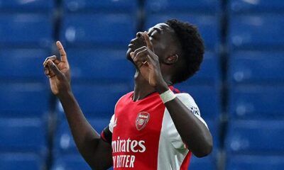 Bukayo Saka celebrating a goal in an Arsenal jersey during a Premier League match.