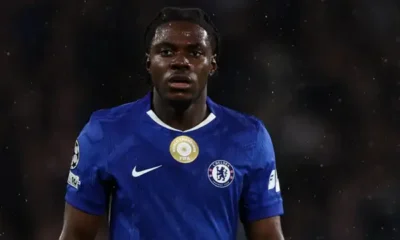 Chelsea midfielder Romeo Lavia walks off the pitch injured during a UEFA Champions League match against Qarabag, as manager Enzo Maresca looks on with concern.
