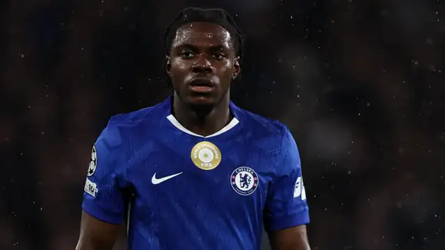 Chelsea midfielder Romeo Lavia walks off the pitch injured during a UEFA Champions League match against Qarabag, as manager Enzo Maresca looks on with concern.