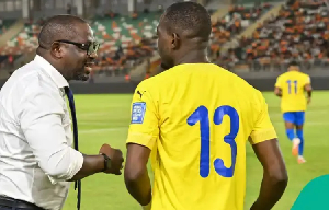 Gabon national team coach Thierry Mouyouma giving instructions during a match.