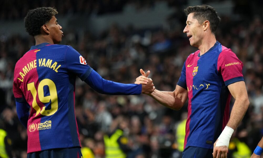 Lamine Yamal and Robert Lewandowski celebrating a goal together for Barcelona during a La Liga match.