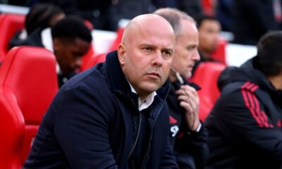 Arne Slot standing on the touchline during a Liverpool match looking under pressure.