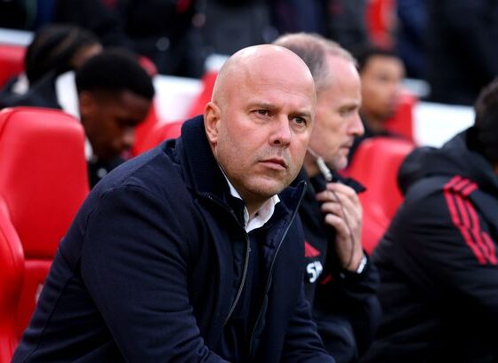 Arne Slot standing on the touchline during a Liverpool match looking under pressure.
