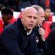 Arne Slot standing on the touchline during a Liverpool match looking under pressure.
