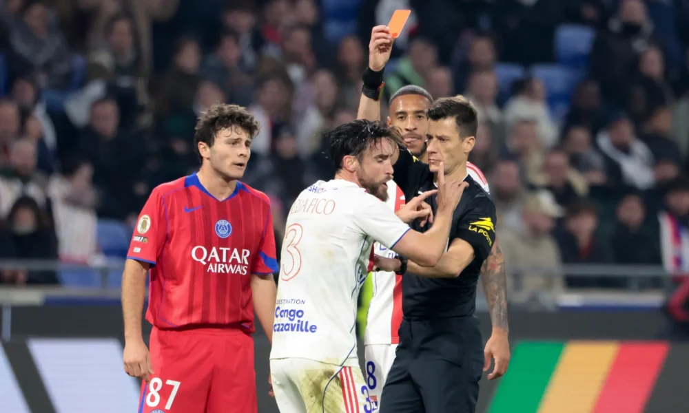PSG players celebrate a late goal against Lyon in Ligue 1 as Lyon players protest to the referee.