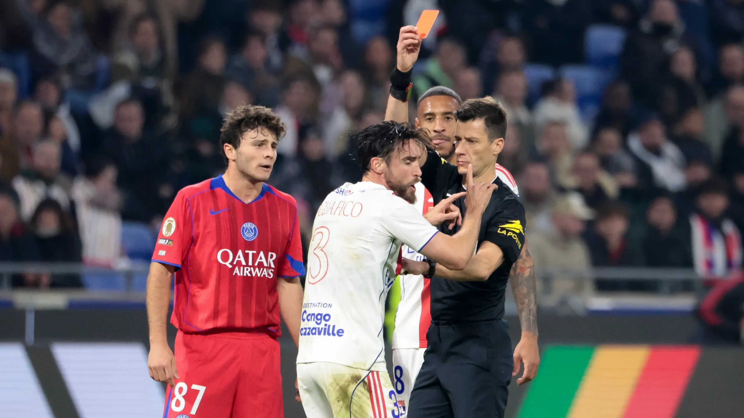 PSG players celebrate a late goal against Lyon in Ligue 1 as Lyon players protest to the referee.