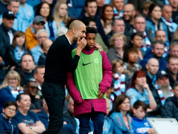 Pep Guardiola giving tactical instructions on the Manchester City touchline.