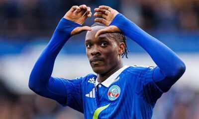 Strasbourg striker Emanuel Emegha celebrates after scoring a goal during a Ligue 1 match, wearing the club’s blue jersey.