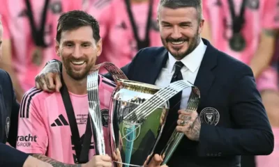 Lionel Messi lifting the MLS Cup trophy with Inter Miami players celebrating.