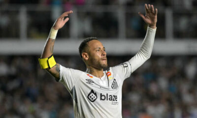 Neymar celebrating in a Santos shirt after signing a contract extension