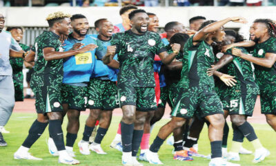 Super Eagles players celebrating on the pitch after AFCON 2025