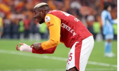 Victor Osimhen celebrating for Galatasaray while gesturing to protective arm bandage after derby win over Fenerbahçe.