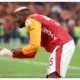Victor Osimhen celebrating for Galatasaray while gesturing to protective arm bandage after derby win over Fenerbahçe.
