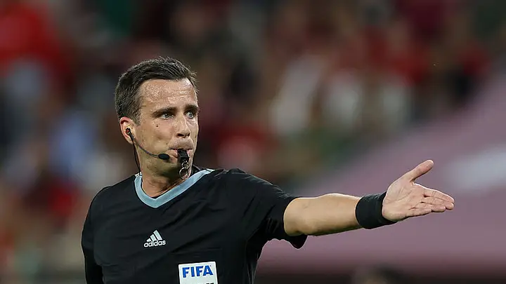 A FIFA referee explaining new football laws ahead of the 2026 FIFA World Cup.